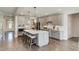 Spacious kitchen with gray cabinets, an island with seating, stainless steel appliances, and hardwood floors at 111 Demascus Way # 021, Four Oaks, NC 27524