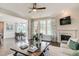 Open-concept living room with a fireplace, hardwood floors, large windows, and a view into the dining area at 111 Demascus Way # 021, Four Oaks, NC 27524