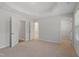 Expansive bedroom with soft carpeting, tray ceiling, and multiple doorways leading to other rooms at 9216 Leaning Post Rd # 447, Wake Forest, NC 27587