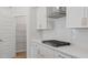 Modern kitchen showcasing white cabinetry, stainless steel appliances, and a sleek cooktop with a vent hood at 9216 Leaning Post Rd # 447, Wake Forest, NC 27587