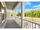 Relaxing covered porch showing white pillars, railing, and a view of the water at 9216 Leaning Post Rd # 447, Wake Forest, NC 27587