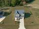 Aerial view of a home showcasing its well-manicured lawn, driveway, and lush, green surroundings at 120 W Weatherford Dr, Angier, NC 27501