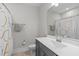 Bright bathroom with a modern vanity, large mirror, and shower with a colorful curtain at 120 W Weatherford Dr, Angier, NC 27501