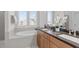 Luxurious bathroom with double sinks, granite counters, and a soaking tub with natural light at 120 W Weatherford Dr, Angier, NC 27501