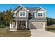 Charming two-story home featuring a stone and siding facade, attached garage and well-manicured landscaping at 120 W Weatherford Dr, Angier, NC 27501