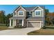 Charming two-story home featuring a stone and siding facade, attached garage and well-manicured landscaping at 120 W Weatherford Dr, Angier, NC 27501