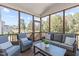Relaxing screened porch featuring wicker furniture and a view of the landscaped backyard at 120 W Weatherford Dr, Angier, NC 27501