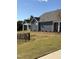 A wide shot of the home's exterior reveals blue siding and white trim, complemented by well-manicured landscaping at 1230 Linkwood, Homesite 44, Fuquay Varina, NC 27526