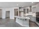 An open kitchen features a spacious island, gray cabinetry, stainless appliances, and views to the dining room at 1230 Linkwood, Homesite 44, Fuquay Varina, NC 27526