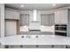 A kitchen showcasing gray cabinetry, stainless steel appliances, a modern range hood, and a spacious island at 1230 Linkwood, Homesite 44, Fuquay Varina, NC 27526