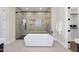 Modern bathroom featuring a soaking tub and glass-enclosed shower with tile surround and a door to the walk-in closet at 662 Manchester Dr, Raleigh, NC 27609