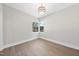 Clean, empty bedroom featuring hardwood floors, a modern light fixture, and a large bay window at 662 Manchester Dr, Raleigh, NC 27609