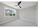 Bright bedroom features a ceiling fan and large window offering a view of the lush outdoors at 662 Manchester Dr, Raleigh, NC 27609