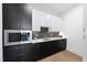 Modern kitchen featuring black and white cabinets, stainless steel microwave, and hardwood floors at 662 Manchester Dr, Raleigh, NC 27609