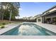 Stunning pool and spa area with a patio, reflecting the sky, complemented by a well-manicured lawn and a modern home exterior at 662 Manchester Dr, Raleigh, NC 27609