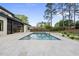 Backyard oasis showcasing a pristine pool, spa, and covered outdoor kitchen, surrounded by lush landscaping and a serene ambiance at 662 Manchester Dr, Raleigh, NC 27609