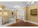Bright hallway featuring hardwood floors with patterned rug, white trim, and classic chandelier at 3105 Cone Manor Ln, Raleigh, NC 27613