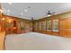 Large living room with wood paneling, built-in shelving, and backyard views at 3105 Cone Manor Ln, Raleigh, NC 27613