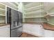 Walk-in pantry with stainless steel refrigerator, custom shelving, and hardwood floors at 3105 Cone Manor Ln, Raleigh, NC 27613