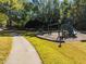 A charming playground and picnic tables sit next to a path surrounded by beautiful green grass and mature trees at 3105 Cone Manor Ln, Raleigh, NC 27613