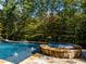 Beautiful stone pool and spa with lush trees surrounding the area at 3105 Cone Manor Ln, Raleigh, NC 27613