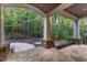 Covered outdoor patio with stone flooring and picturesque views of the wooded backyard at 3105 Cone Manor Ln, Raleigh, NC 27613