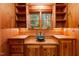 Custom wet bar in a wood paneled room with a view to the backyard at 3105 Cone Manor Ln, Raleigh, NC 27613