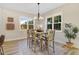 Bright dining area features a modern chandelier, light wood floors, and large windows with a view of greenery at 9314 Turkey Way, Middlesex, NC 27557