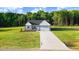 Well-manicured front lawn and driveway leading to a charming one-story home, complete with an attached two-car garage at 9314 Turkey Way, Middlesex, NC 27557