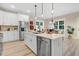 Bright kitchen featuring white cabinetry, stainless steel appliances, an island with barstool seating, and modern fixtures at 9314 Turkey Way, Middlesex, NC 27557