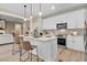 Spacious kitchen offering white cabinetry, stainless steel appliances, a kitchen island, and seamless access to living room at 9314 Turkey Way, Middlesex, NC 27557