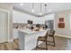 A modern kitchen features white cabinets, stainless steel appliances, pendant lighting, and an island with seating at 9314 Turkey Way, Middlesex, NC 27557