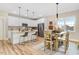 Open kitchen with white cabinets, a stylish island with seating, stainless steel appliances, and an adjacent dining area at 9314 Turkey Way, Middlesex, NC 27557
