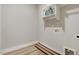 Bright laundry room with wood-look flooring, utility connections, and white shelving at 9314 Turkey Way, Middlesex, NC 27557