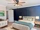 Primary bedroom with a ceiling fan, stylish accent wall, and comfortable furnishings at 1011 Lemon Dr, Durham, NC 27705