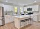 Modern kitchen with an island, stainless steel appliances, white cabinets, and mosaic backsplash at 1011 Lemon Dr, Durham, NC 27705
