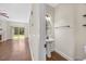 Cozy half-bathroom featuring a pedestal sink, round mirror, and wooden shelving, next to the living area at 2024 Stanchion St, Haw River, NC 27258