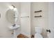 Well-lit powder room features pedestal sink, decorative mirror, and toilet with convenient wooden wall shelves at 2024 Stanchion St, Haw River, NC 27258