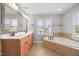 Bathroom with dual sinks, a garden tub, and a large mirror at 2024 Stanchion St, Haw River, NC 27258