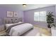 Cozy bedroom with soft purple walls, plush carpeting, and a serene view from the bright window at 2024 Stanchion St, Haw River, NC 27258