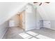 This large bonus room features a ceiling fan, carpeting, storage access doors, and a window for natural light at 2024 Stanchion St, Haw River, NC 27258