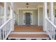 Inviting front porch with wood flooring, white columns, and a view of the front yard at 2024 Stanchion St, Haw River, NC 27258