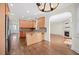 Open kitchen with hardwood flooring, island, and stainless steel appliances seamlessly flowing into the living area at 2024 Stanchion St, Haw River, NC 27258