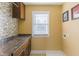 Bright laundry room with mosaic tile backsplash, dark countertops, and a window for natural light at 2024 Stanchion St, Haw River, NC 27258