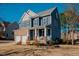 Two-story home with brick and siding exterior, two-car garage, and front porch at 454 Big Willow Way, Rolesville, NC 27571