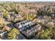 Aerial view featuring modern townhomes with rooftop decks near Atlanta skyline, surrounded by trees, and a winding road at 811 Maple Berry Ln # 101, Raleigh, NC 27607