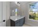 Bathroom with a modern vanity featuring ample storage and a large mirror reflecting natural light from the window at 811 Maple Berry Ln # 101, Raleigh, NC 27607