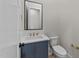 Stylish bathroom featuring a navy blue vanity with gold hardware and a square mirror at 811 Maple Berry Ln # 101, Raleigh, NC 27607