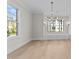 Inviting dining area featuring large windows, stylish light fixture, and hardwood floors for elegant entertaining at 811 Maple Berry Ln # 101, Raleigh, NC 27607