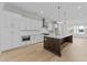 Modern kitchen featuring white cabinets, stainless steel appliances, a center island, and hardwood floors at 811 Maple Berry Ln # 101, Raleigh, NC 27607